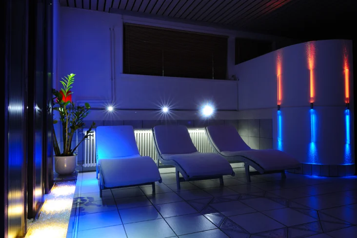 Drei Liegen im blauen Abendlicht im Erholungsraum der Sauna im Frauenhotel Revital auf dem Balcon du Jura.