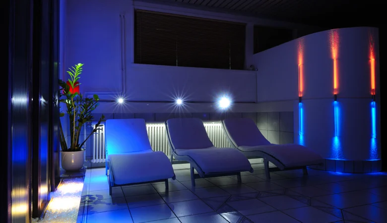 Drei Liegen im blauen Abendlicht im Erholungsraum der Sauna im Frauenhotel Revital auf dem Balcon du Jura.