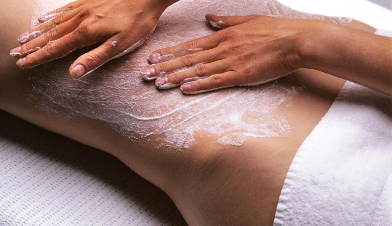 Behandlung im Frauenhotel Revital auf dem Balcon du Jura. Eine Frau liegt auf einer Massageliege und geniesst ein Rückenpeeling.