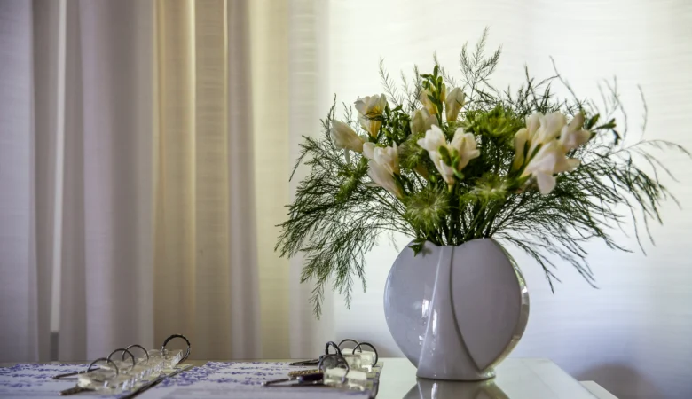 Rezeption Frauenhotel Revital auf dem Balcon du Jura. Die Schlüssel liegen schön geordnet auf dem Tresen neben einer Vase mit Blumen.